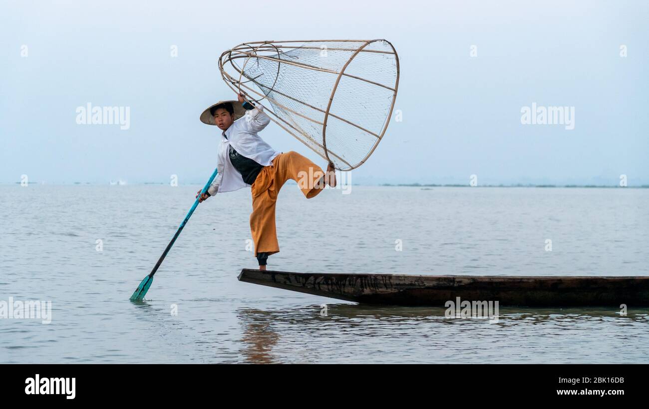 Nyaungshwe, Myanmar : 12. März 2020 - Fischer Pose für ein Bild Inle Lake. Einst ein alter Traditionsfischer macht jetzt Geld, indem er für Fotos posiert. Stockfoto