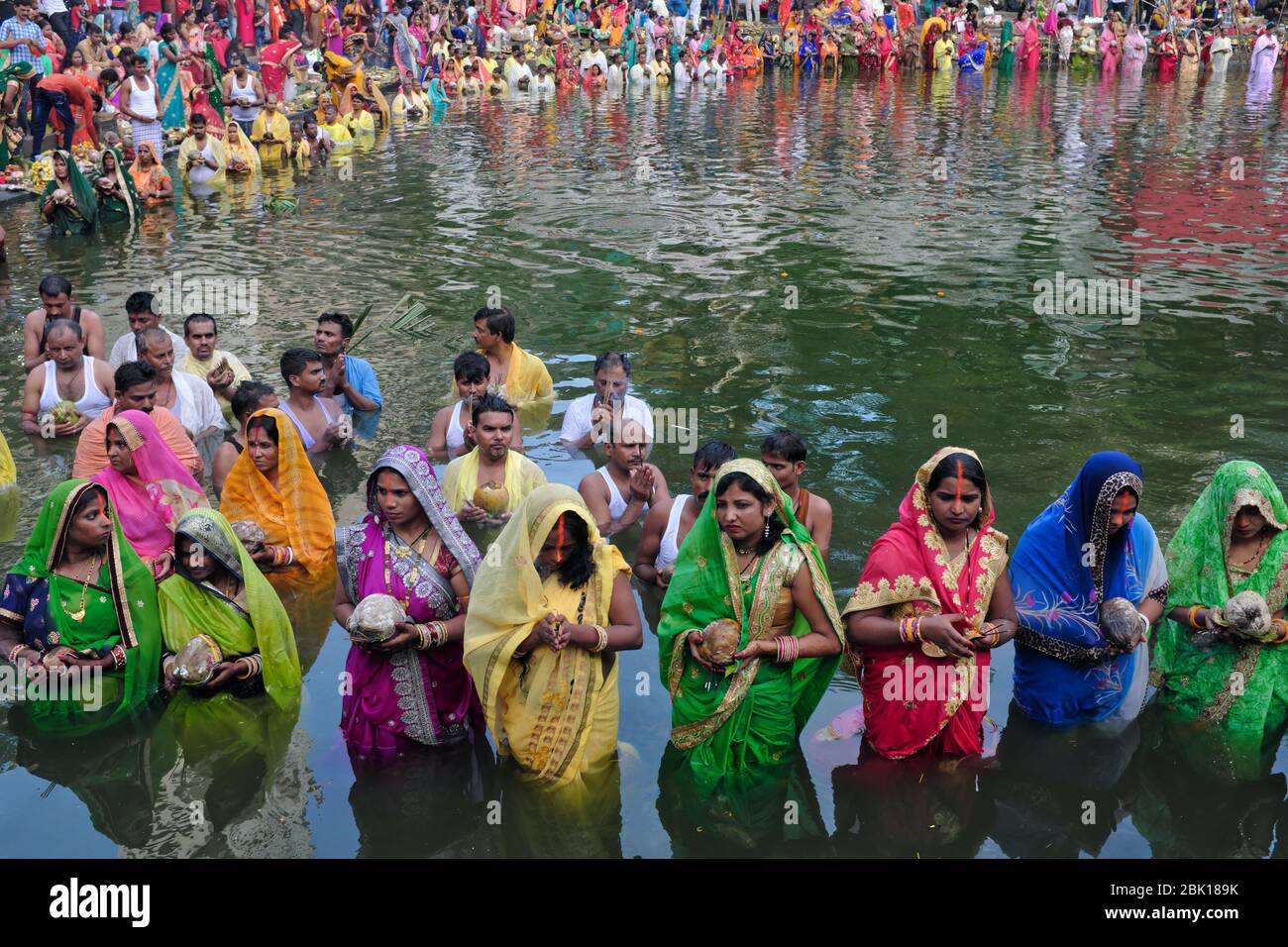 Während des Festivals Chhath Puja, Gläubige, meist Migranten aus der Provinz Bihar, stehen in Banganga Tank, Mumbai, Indien, um in Richtung der untergehenden Sonne zu beten Stockfoto