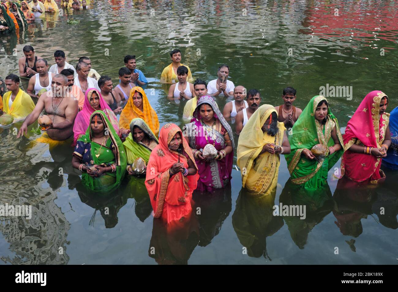 Während des Festivals Chhath Puja, Gläubige, meist Migranten aus der Provinz Bihar, stehen in Banganga Tank, Mumbai, Indien, um in Richtung der untergehenden Sonne zu beten Stockfoto