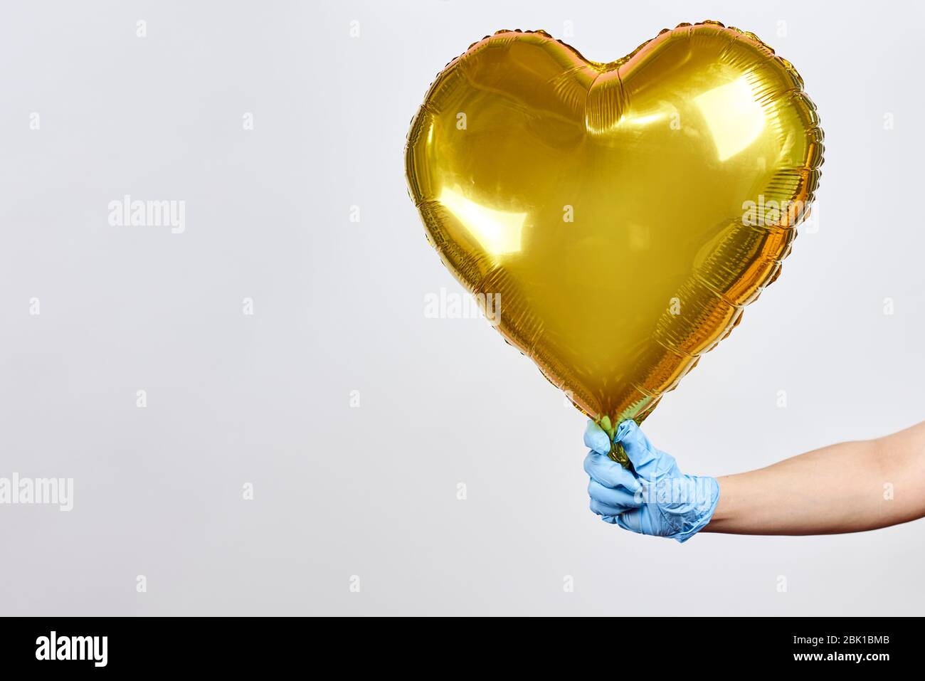 Ärztin mit goldenem festlichem Luftballon, Symbol für Hoffnung für Patienten mit Covid-19 infiziert. Konzept der Krankenversicherung Stockfoto