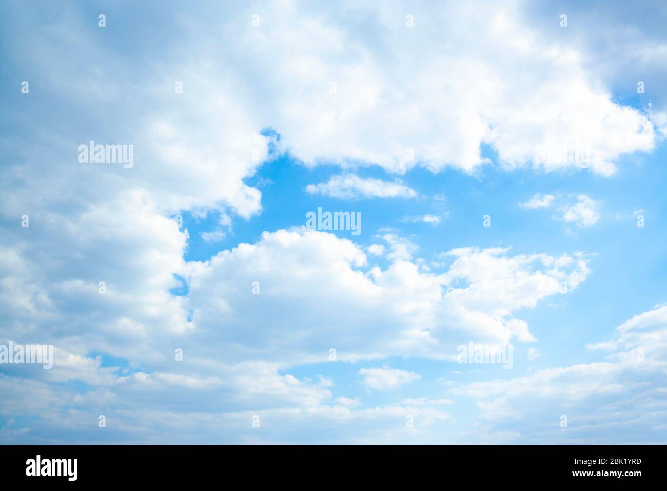 Riesige Wolken in blauem Himmel von der Sonne beleuchtet, nicht windig. Stockfoto