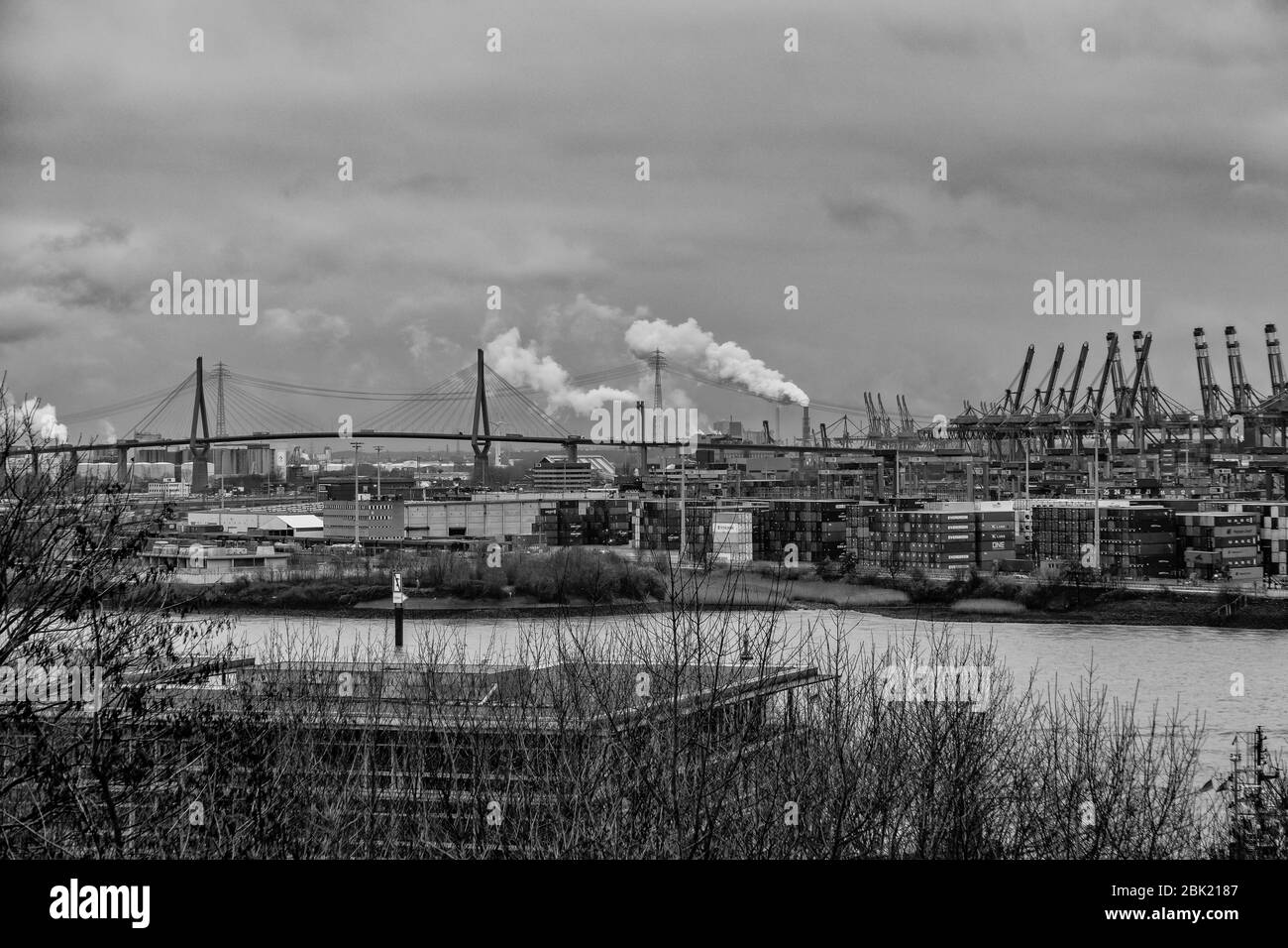 Atemberaubende Panoramasicht auf den Hamburger Hafen mit Containerterminal und der Köhlbrandbrücke an der Elbe mit dramatischem Himmel/Wolken, deutsch Stockfoto