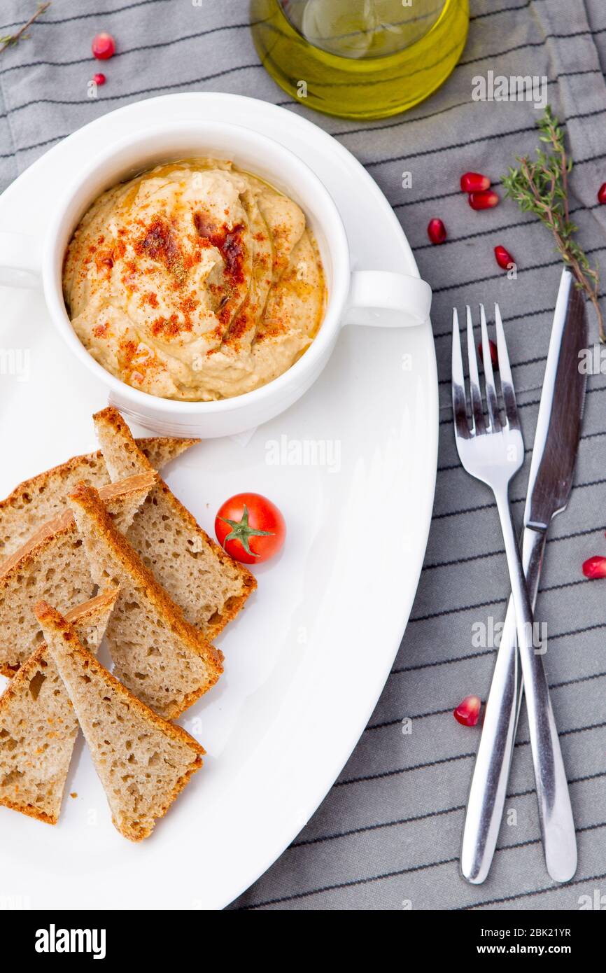 Veganer Hummus, hergestellt aus Kichererbsen und Tahini, mit Olivenöl und Knoblauch. Stockfoto
