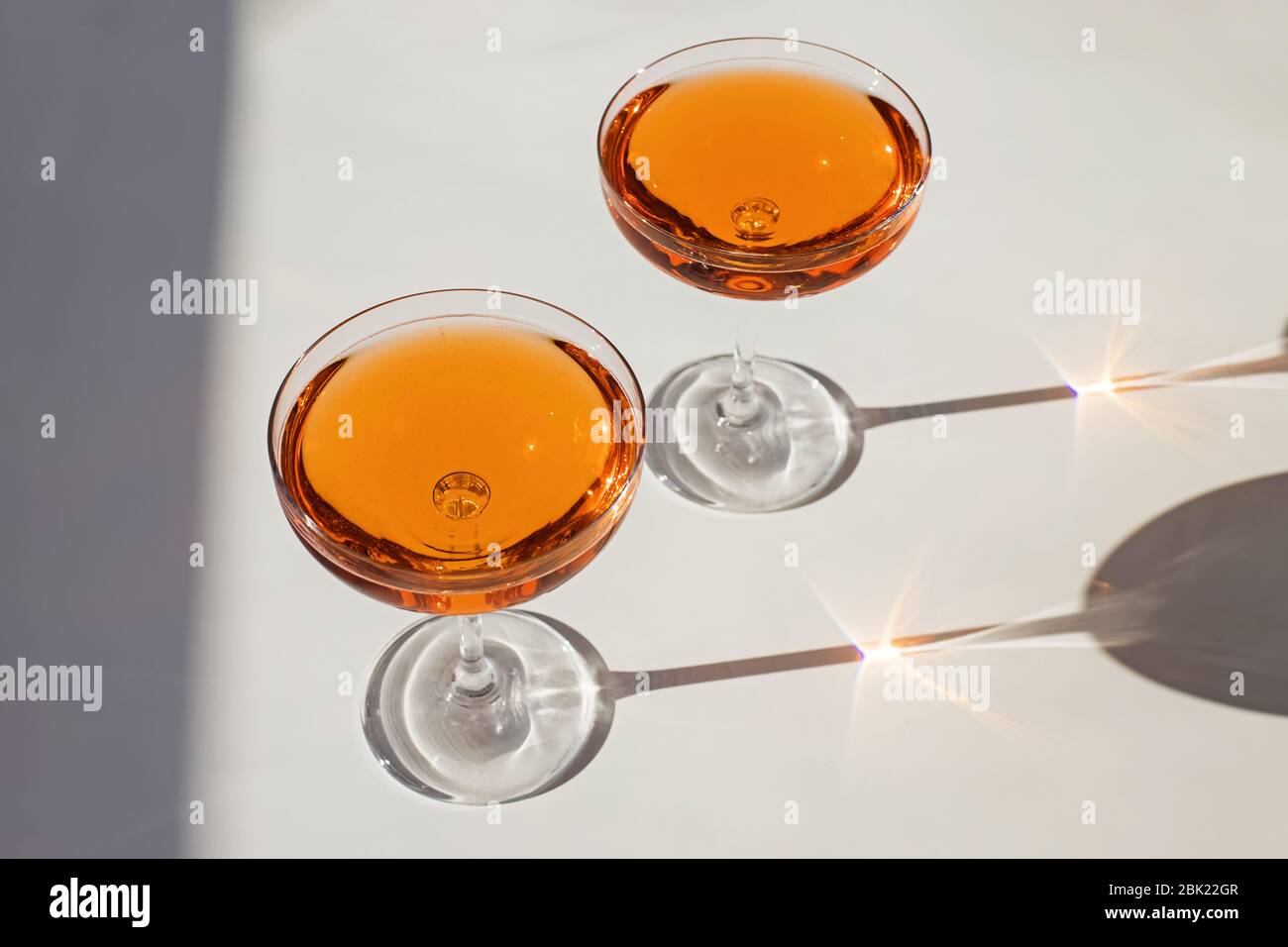 Zwei Gläser Cocktail mit Sekt auf dem weißen Tisch in natürlichem Sonnenlicht Stockfoto