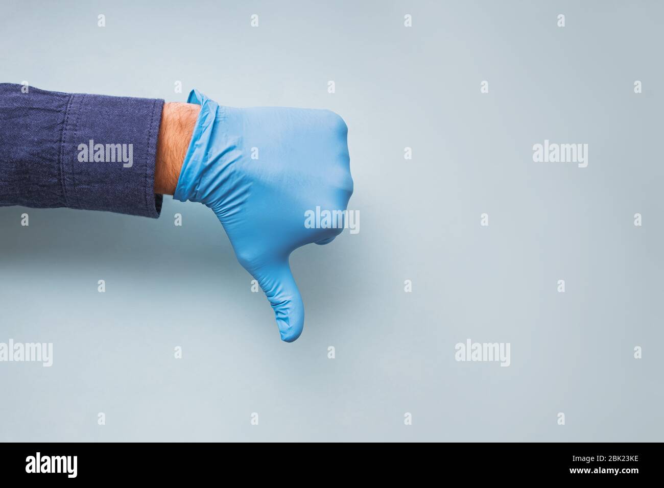Hand in blauem medizinischen Handschuh mit Abstumpfschild Stockfoto