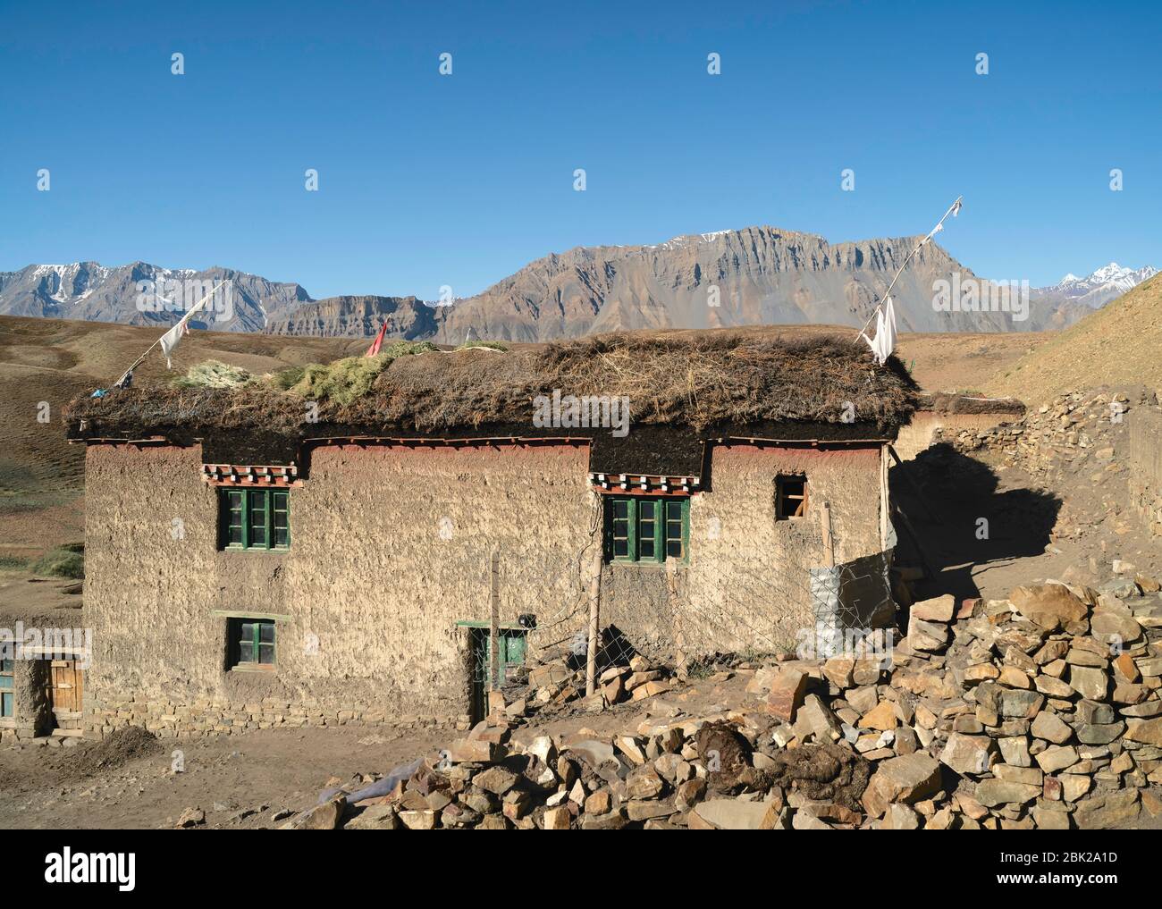 Traditionelles Schlamm verputztes Haus und Tierfutter trocknen auf dem Dach unter dem Himalaya in einem isolierten Dorf. Komic, Indien. Stockfoto