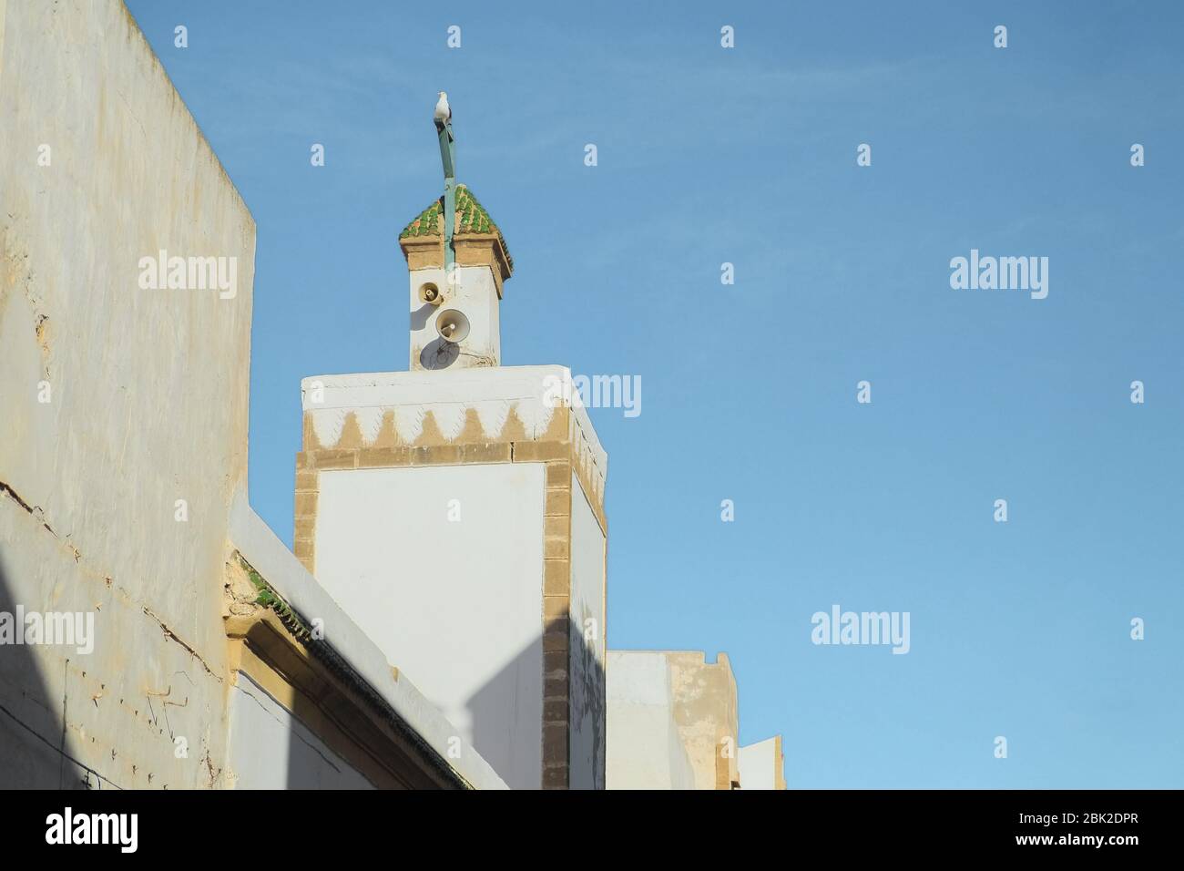 Muslimische weiße Minarett Turm für Aufruf Gebet an der lokalen Moschee vor blauem Himmel Hintergrund zu beten Stockfoto