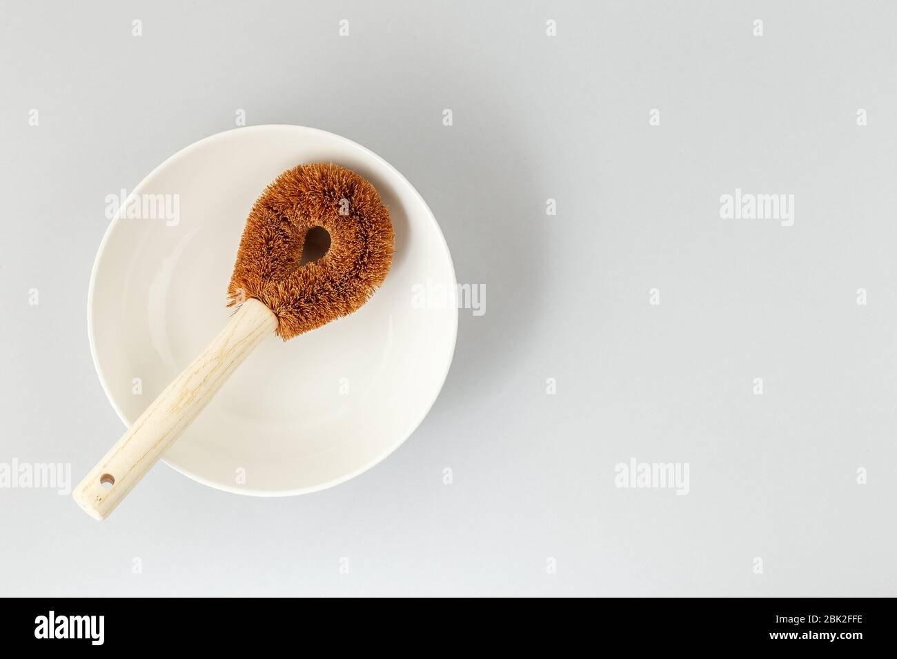 Runde, abfallfreie Kokosnussbürste und weiße Schale für nachhaltige Hausreinigung Stockfoto