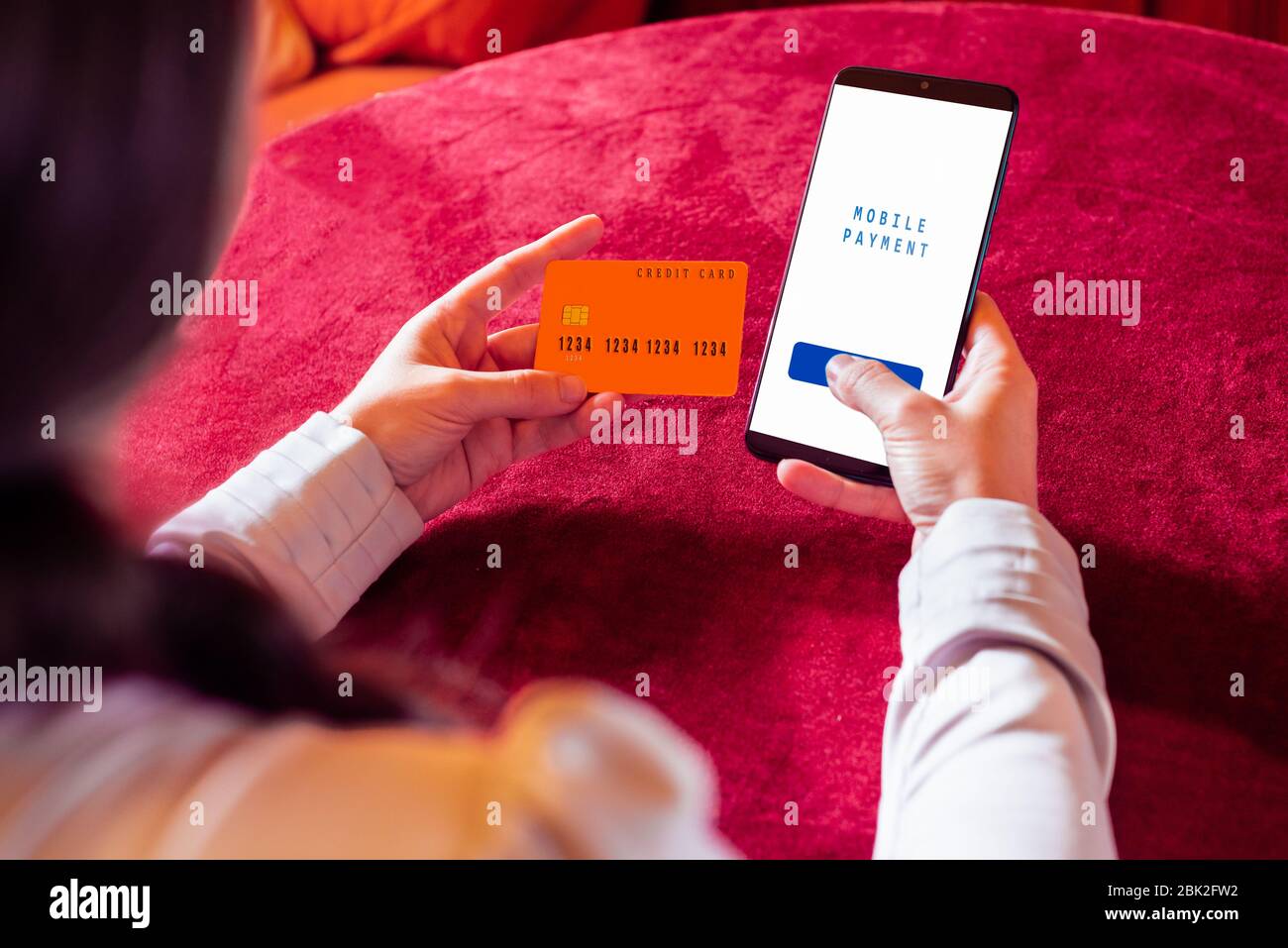 Menschliche Hand hält Smartphone mit Online-Shopping-App und Kreditkarte. Stockfoto