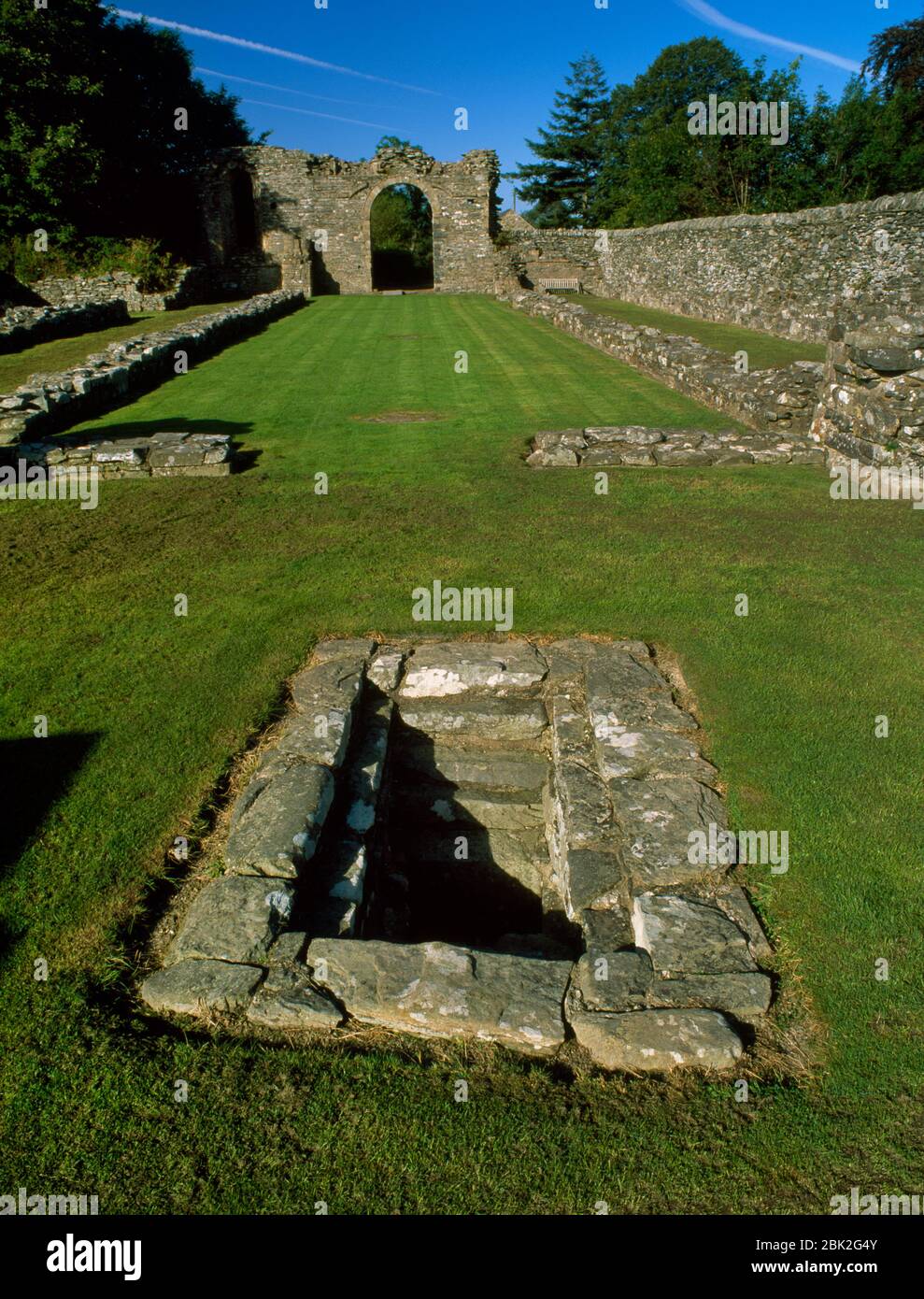 Blick W hinunter das Kirchenschiff (Laienbruderchor) der Zisterzienserabtei Strata Florida, Ceredigion, Wales, Großbritannien, zeigt ein steingesäumtes Becken im Mönchschor Stockfoto