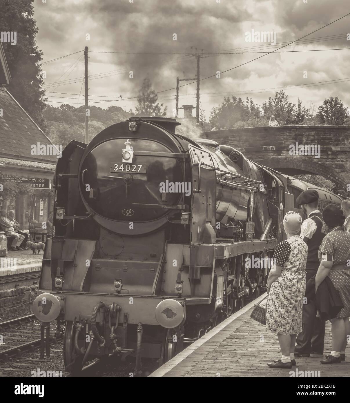 Monochrome, nostalgische Vorderansicht des alten britischen Dampfzugs, der an der Arley Station, der historischen Eisenbahn Severn Valley, im Zweiten Weltkrieg während der 1940er Jahre anfährt. Stockfoto