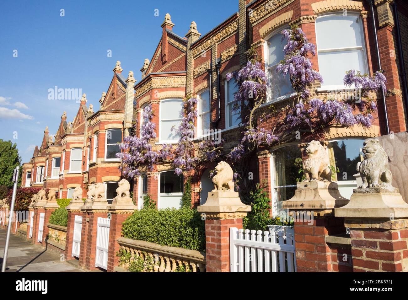 Löwenstatuen auf den Giebeln und Pfosten der Wisteria Clad Lion Houses in Barnes, London, SW13, Großbritannien Stockfoto