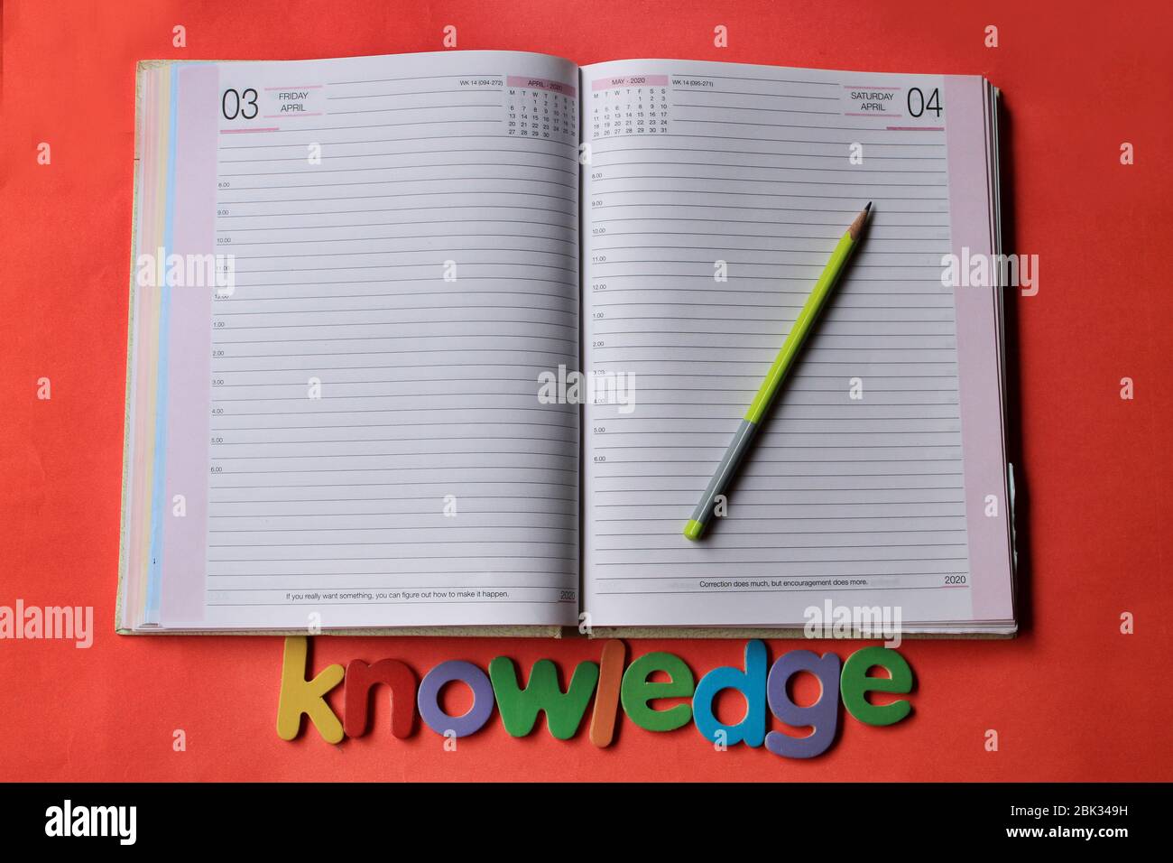 Das Wort Wissen auf rotem Hintergrund mit Tagebuch Seite und Bleistift geschrieben. Stockfoto