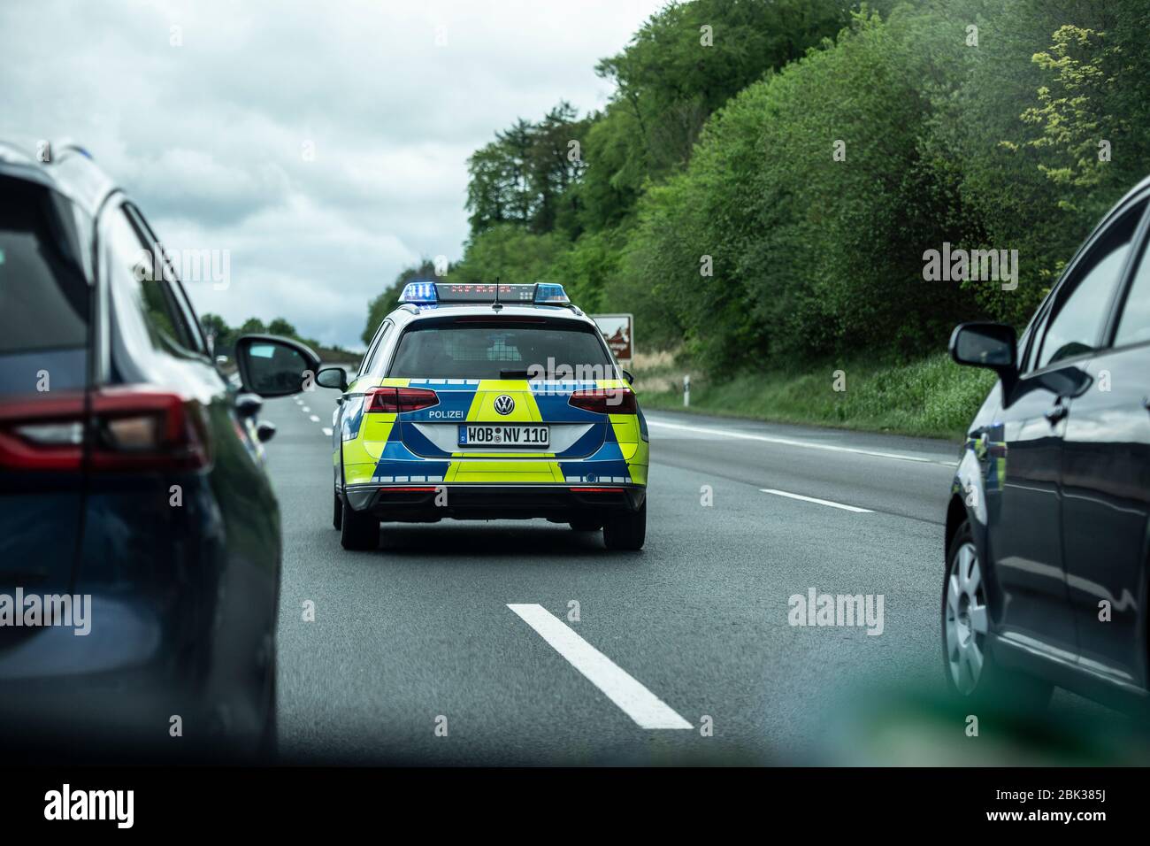 Ein Streifenwagen der Wolfsburger Polizei, ein VW Passat, bremst den Verkehr auf der Autobahn A42 ab, bis er zum Stillstand kommt. Danning defunding Stockfoto
