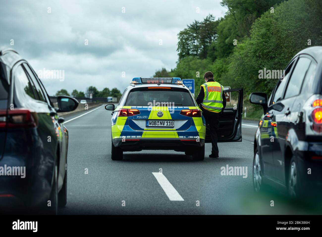 Ein Streifenwagen der Wolfsburger Polizei, ein VW Passat, bremst den Verkehr auf der Autobahn A42 ab, bis er zum Stillstand kommt. Danning defunding Stockfoto