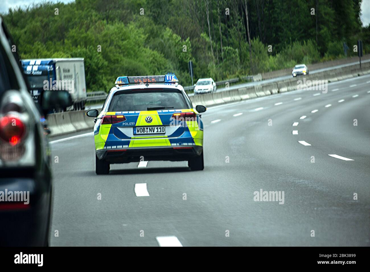 Ein Streifenwagen der Wolfsburger Polizei, ein VW Passat, bremst den Verkehr auf der Autobahn A42 ab, bis er zum Stillstand kommt. Danning defunding Stockfoto