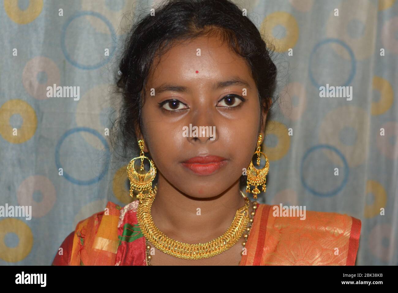 Nahaufnahme eines schönen indischen Mädchen trägt traditionelle große goldene Ohrringe und Halskette, selektive Fokussierung. Stockfoto