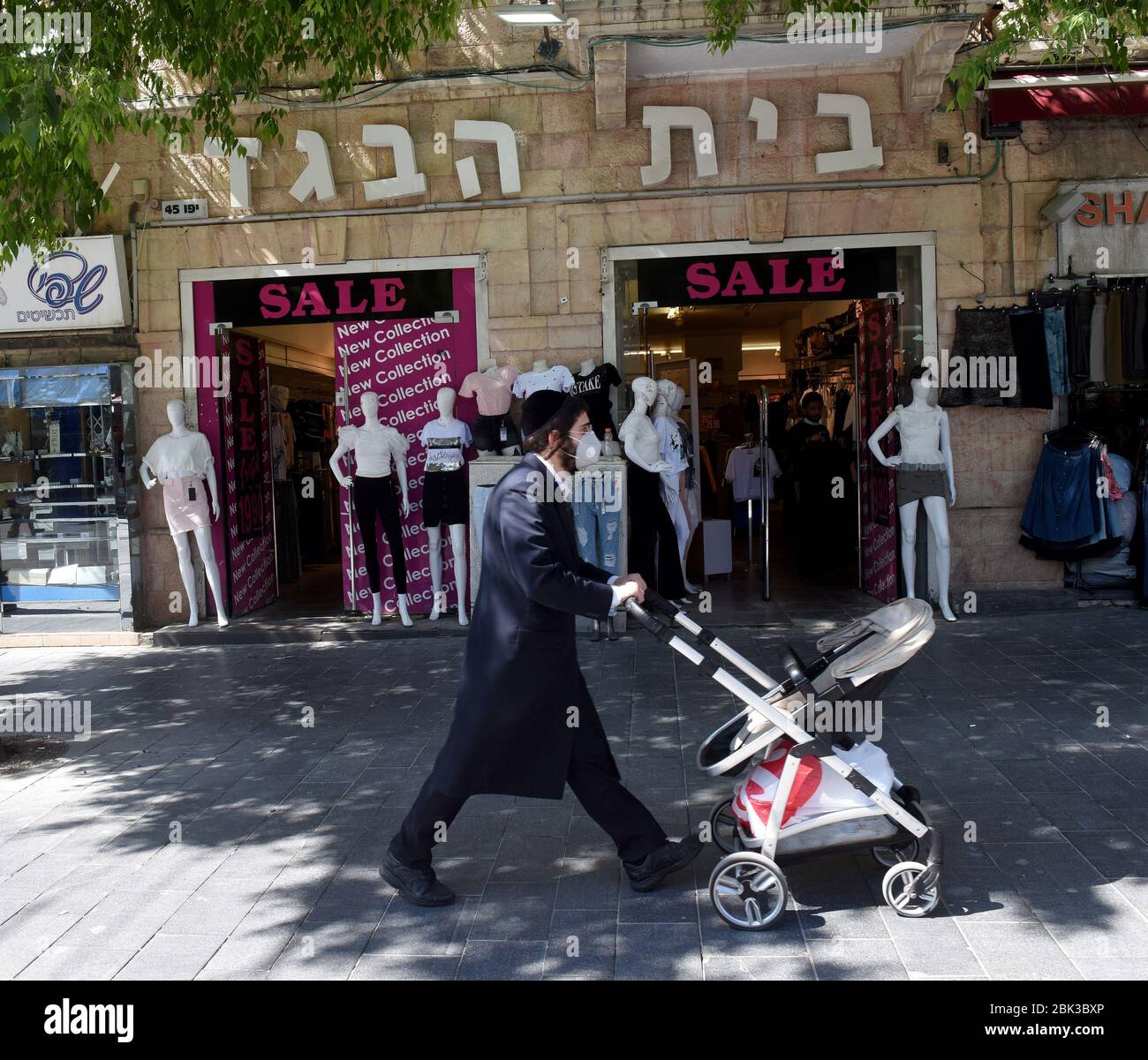 Ein Israeli trägt aufgrund der COVID-19-Pandemie eine obligatorische Gesichtsmaske, während er am Freitag, den 1. Mai 2020, an einem Bekleidungsgeschäft in Jerusalem vorbeiging. Israel hat einige Beschränkungen des Coronavirus gelockert, indem es kleine Geschäfte und Schönheitssalons eröffnet hat, während es die strengen Regeln der sozialen Distanzierung aufrechterhält. Foto von Debbie Hill/UPI Stockfoto