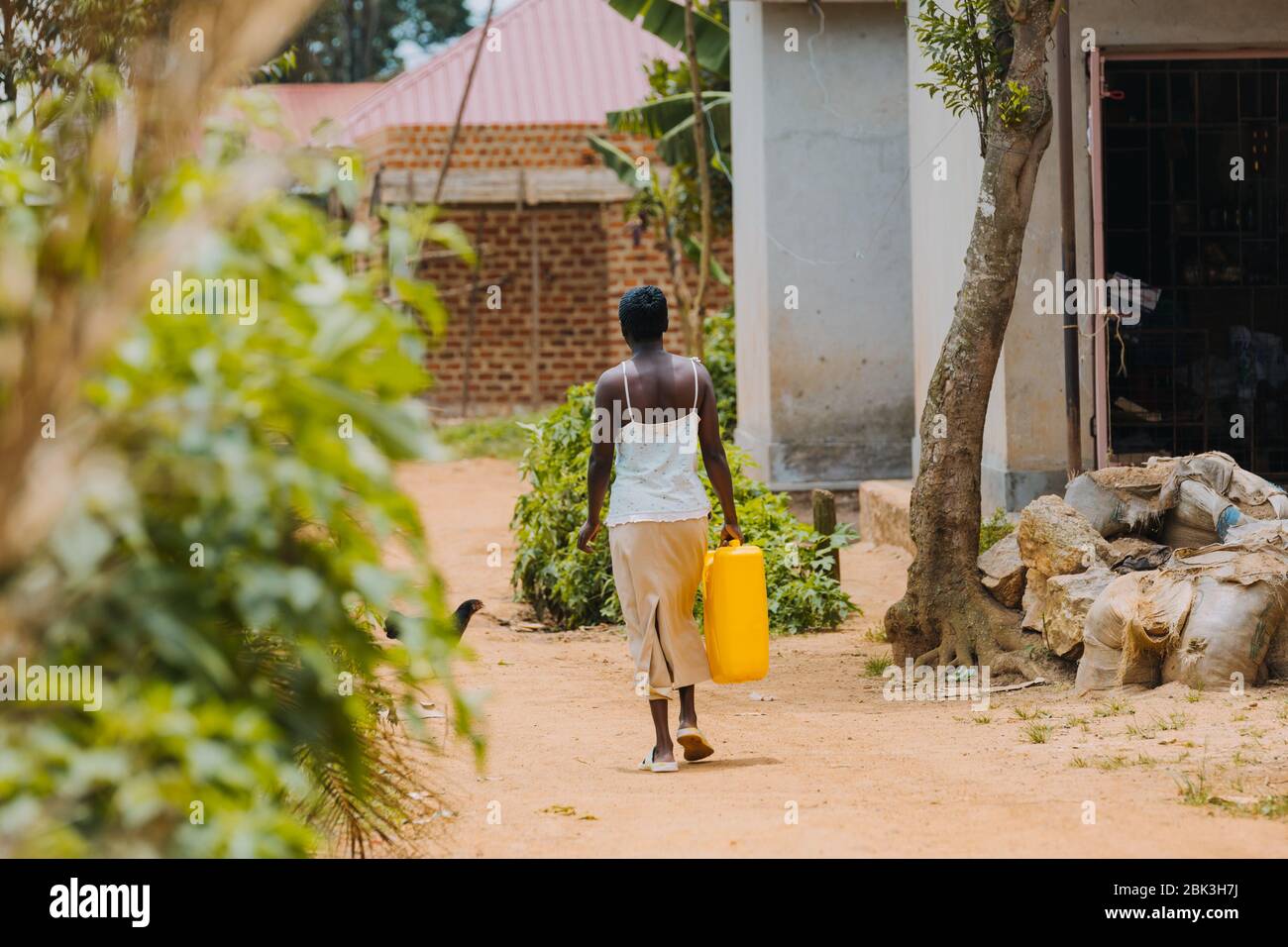 Frau, die Wasser in Entebbe, Uganda, trägt Stockfoto