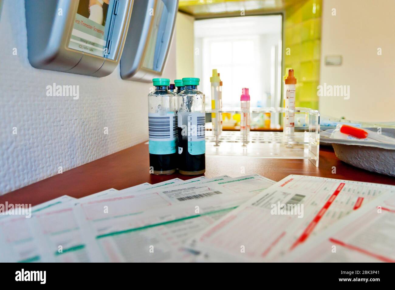 Rack mit Blutgefäßen mit Barcode-Etiketten zur korrekten Identifizierung von verschiedenen Patienten. Tablett mit Röhrchen mit Blutproben, Spritze und Labor Stockfoto