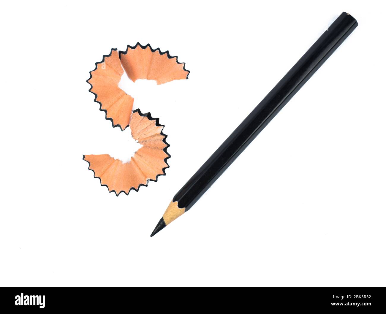 Schwarze Farbe Holz Bleistift Buntstift neben einem s förmigen Holz Bleistift Späne platziert Stockfoto