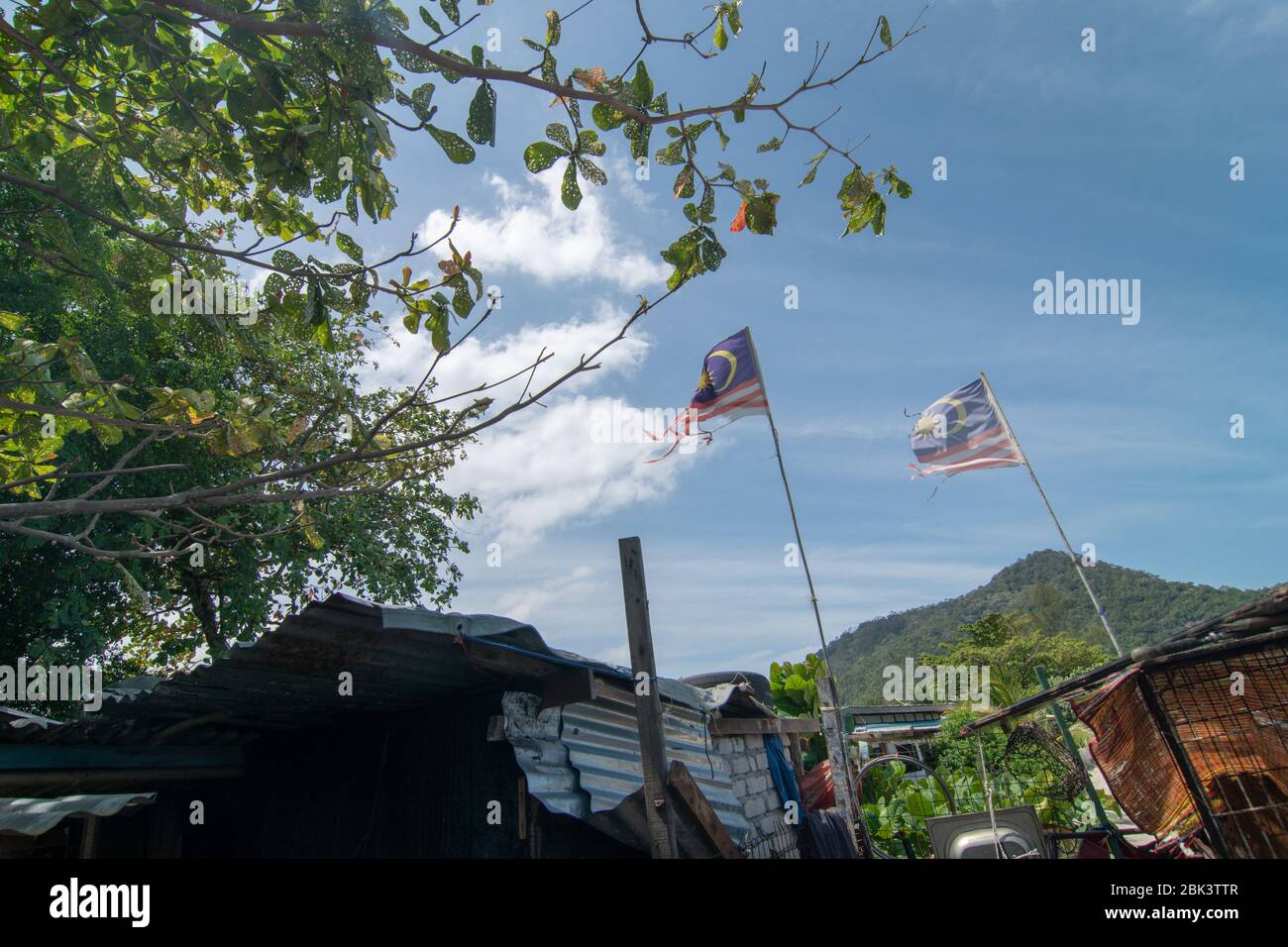 Zwei verblassen Malaysia Flagge winkt auf dem ländlichen malaiischen Dorf. Stockfoto