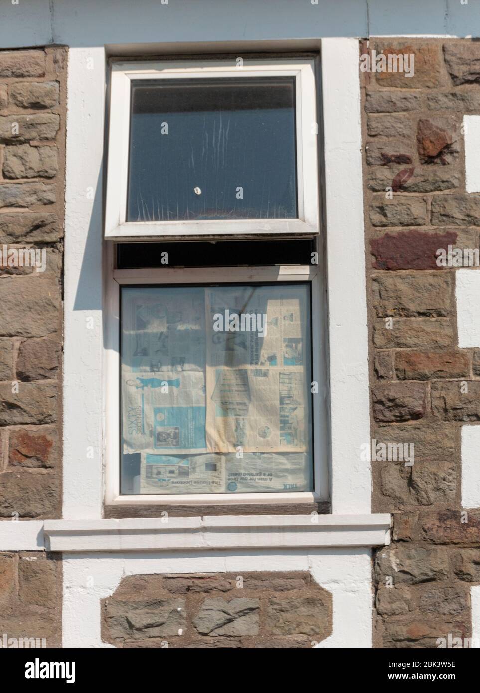 Bristol-April 2020- England-eine Nahaufnahme eines kleinen Fensters, in dem die Zeitung am unteren Teil festgeklebt ist Stockfoto