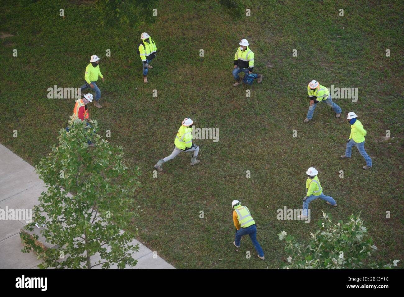 Austin, Texas, USA. April 2020. Bauarbeiter in der Innenstadt von Austin üben soziale Distanz, während sie sich vor einer Morgenschicht ausdehnen, während Texas sich darauf vorbereitet, aufgrund der Coronavirus-Epidemie den Aufenthalt zu Hause und die geschäftlichen Beschränkungen zu erleichtern. Die meisten Unternehmen dürfen am 1. Mai mit Belegungsbeschränkungen eröffnen, obwohl Texas fast 700 Todesfälle aufgrund des Virus verzeichnet hat. Kredit: Bob Daemmrich/ZUMA Wire/Alamy Live News Stockfoto