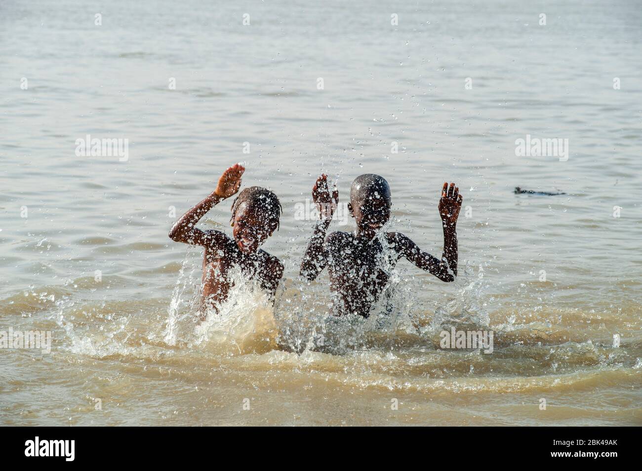 Ein Junge und ein Mädchen spielen und planschen im Wasser des Bani-Flusses in Mopti in Mali, Westafrika. Stockfoto