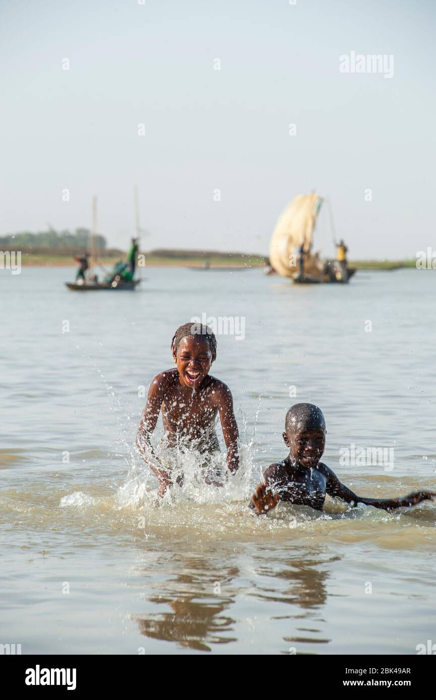 Ein Junge und ein Mädchen spielen und planschen im Wasser des Bani-Flusses in Mopti in Mali, Westafrika. Stockfoto
