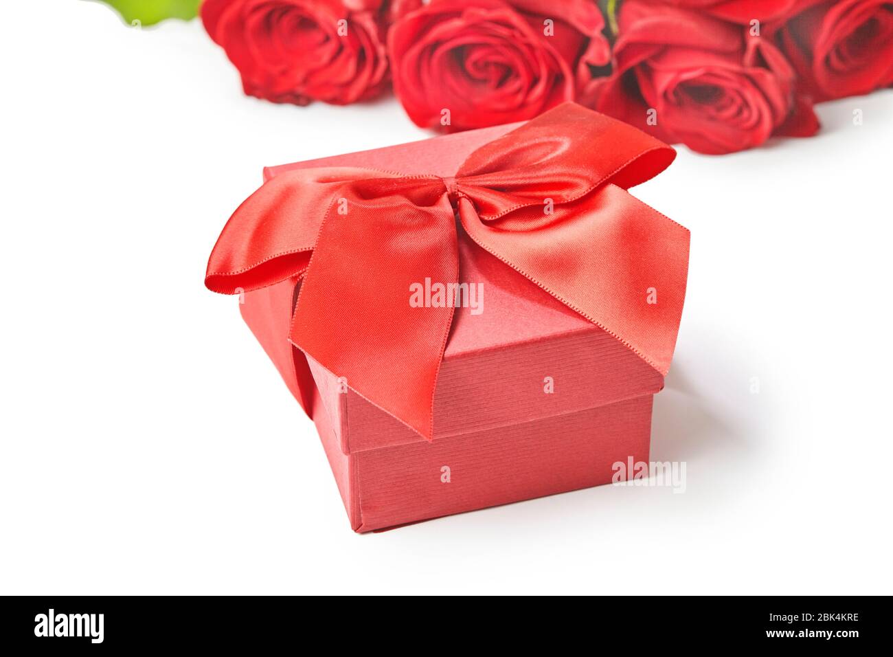 Geschenkbox und rote Rosen auf weißem Hintergrund Draufsicht Stockfoto