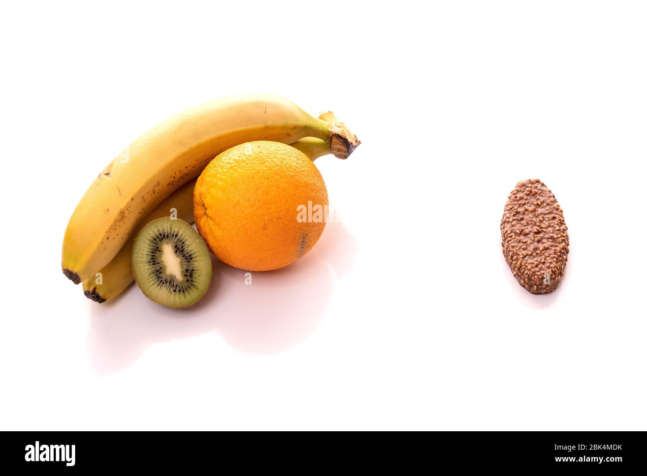 Auswahl zwischen frischem Obst und Schokolade auf weißem Hintergrund Stockfoto