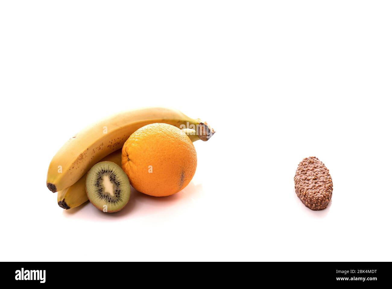 Banane, Kiwi, Orange auf der linken Seite und Schokolade auf der rechten Seite isoliert auf weißem Hintergrund Stockfoto