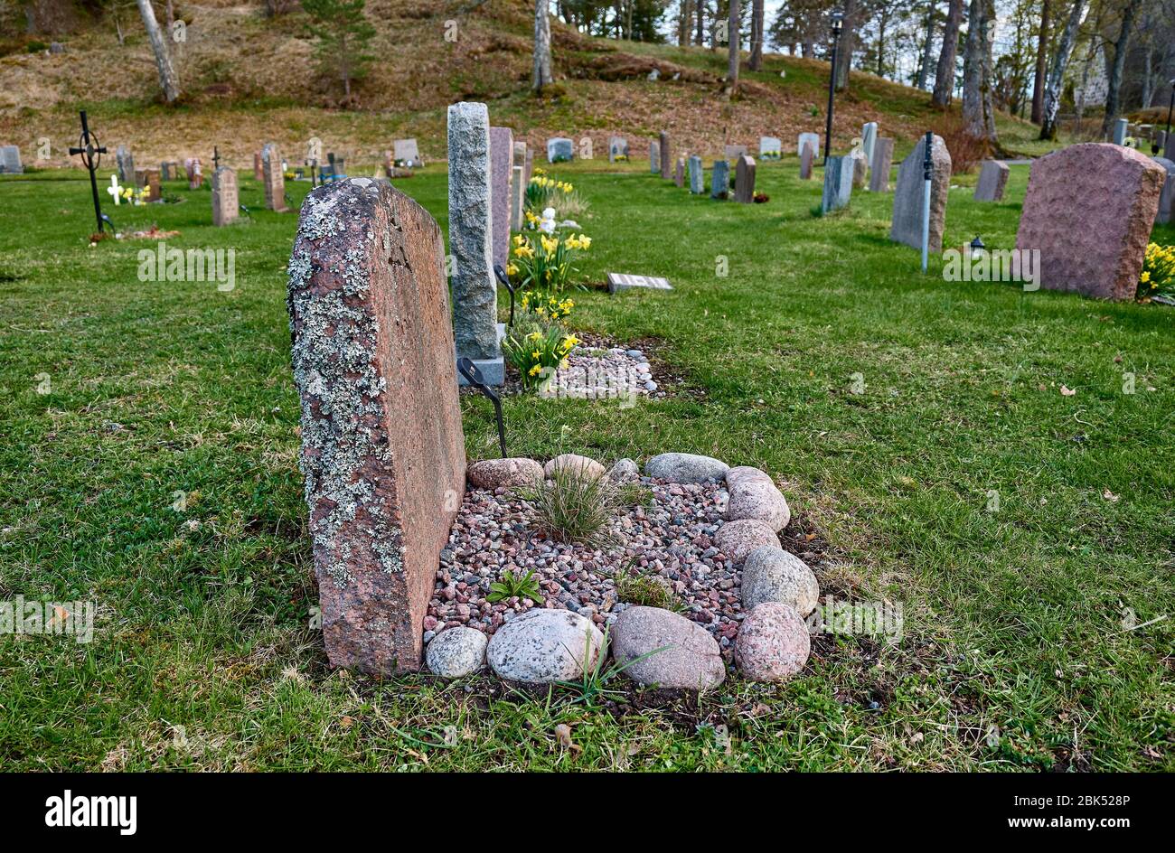 Ein Grabstein mit Moos, aber schön platzierte Steine auf der Vorderseite. Stockfoto