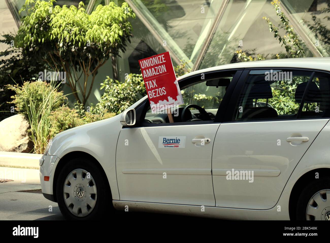 Ein Fahrzeug mit einem Plakat, das während der Demonstration aus dem  Fenster hängt.EINE Karawane von Autos und Radfahrern umkreist das  Amazonashauptquartier, das zur Unterstützung des stadtratmitglieds  demonstriert, Kshama Sawants Vorschlag, neue Steuern