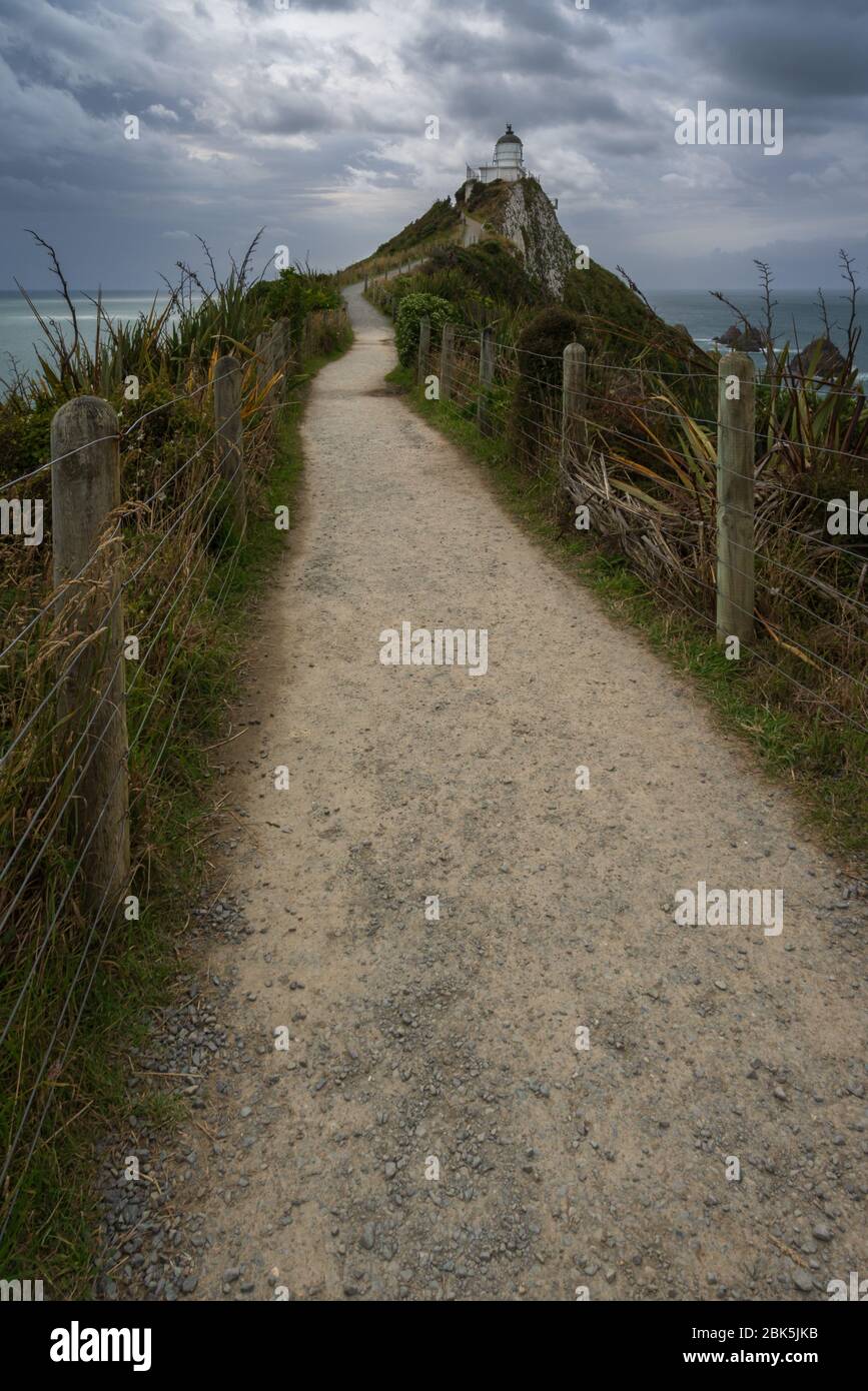 Nugget Point Leuchtturm, Ahuriri flach, Neuseeland - 10. Januar 2020 : der Fußweg zum Nugget Point Leuchtturm an einem stimmungsvollen und bewölkten Nachmittag Stockfoto