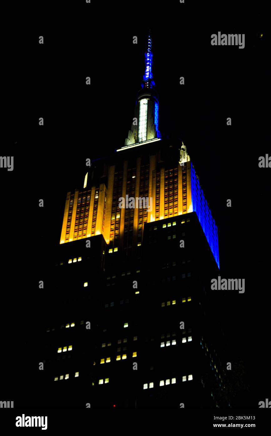 NEW YORK, NY – das Empire State Building leuchtete am 28. April 2020 hier zu Ehren der US-Armee gelb und weiß. Zu Ehren derer, die zur Bekämpfung der COVID-19-Pandemie beitragen, ehrt das Empire State Building Verteidigungs- und Ersthelfer-Organisationen während seiner einwöchigen #HeroesShineBright-Kampagne. (USA Armeefoto von Sgt. 1. Klasse Gregory Williams, 333. Militärpolizei Brigade) Stockfoto