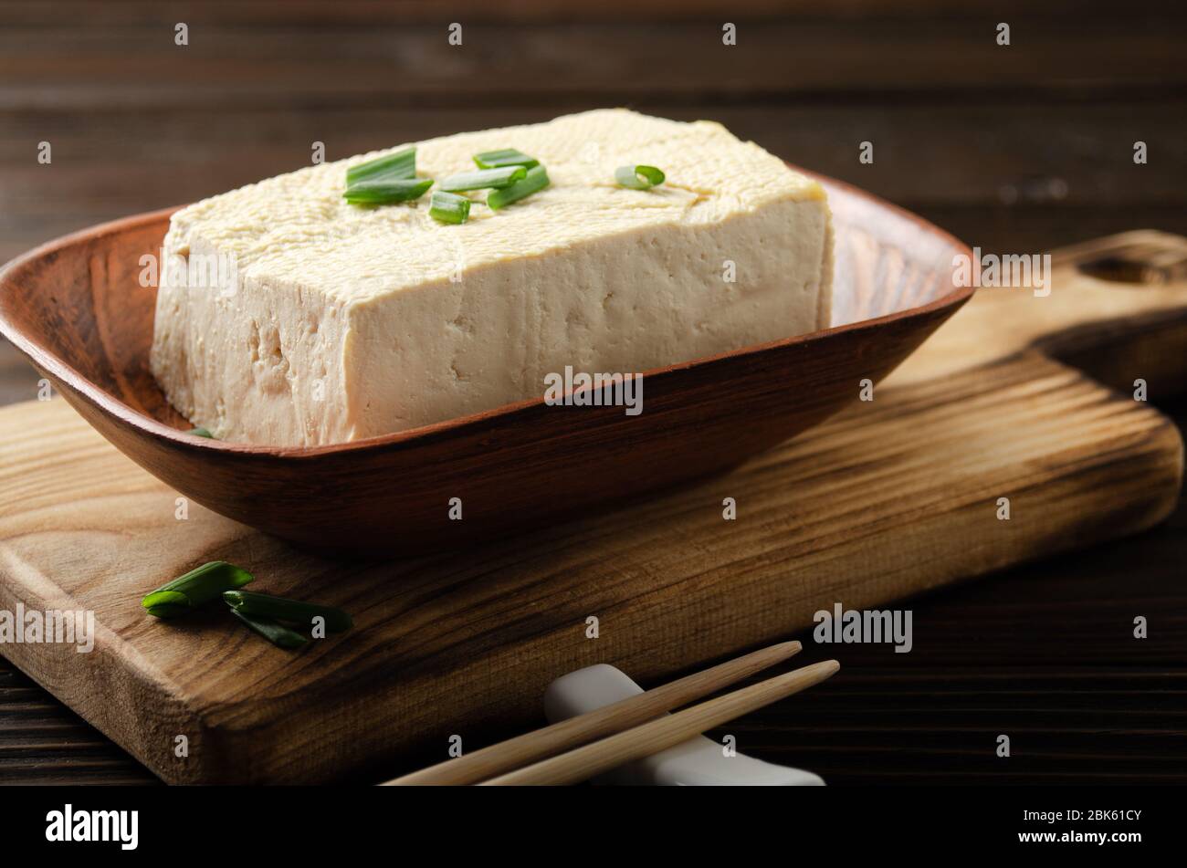 Sojabohnenkoffur Gemüsebohnenkohl in Tonschüssel auf Küchentisch mit Schnittlauch und Essstäbchen beiseite Stockfoto