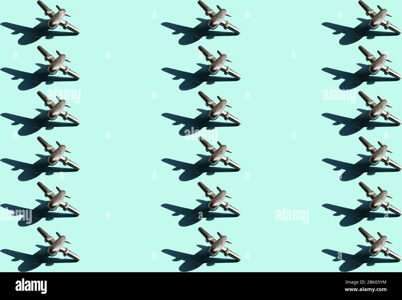 Muster aus drei Linien von Metallfiguren von kleinen Flugzeugen auf dem hellen mintfarbenen Hintergrund. Konzeptionelle geometrische Kunst trendy Foto von achtzehn aircr Stockfoto