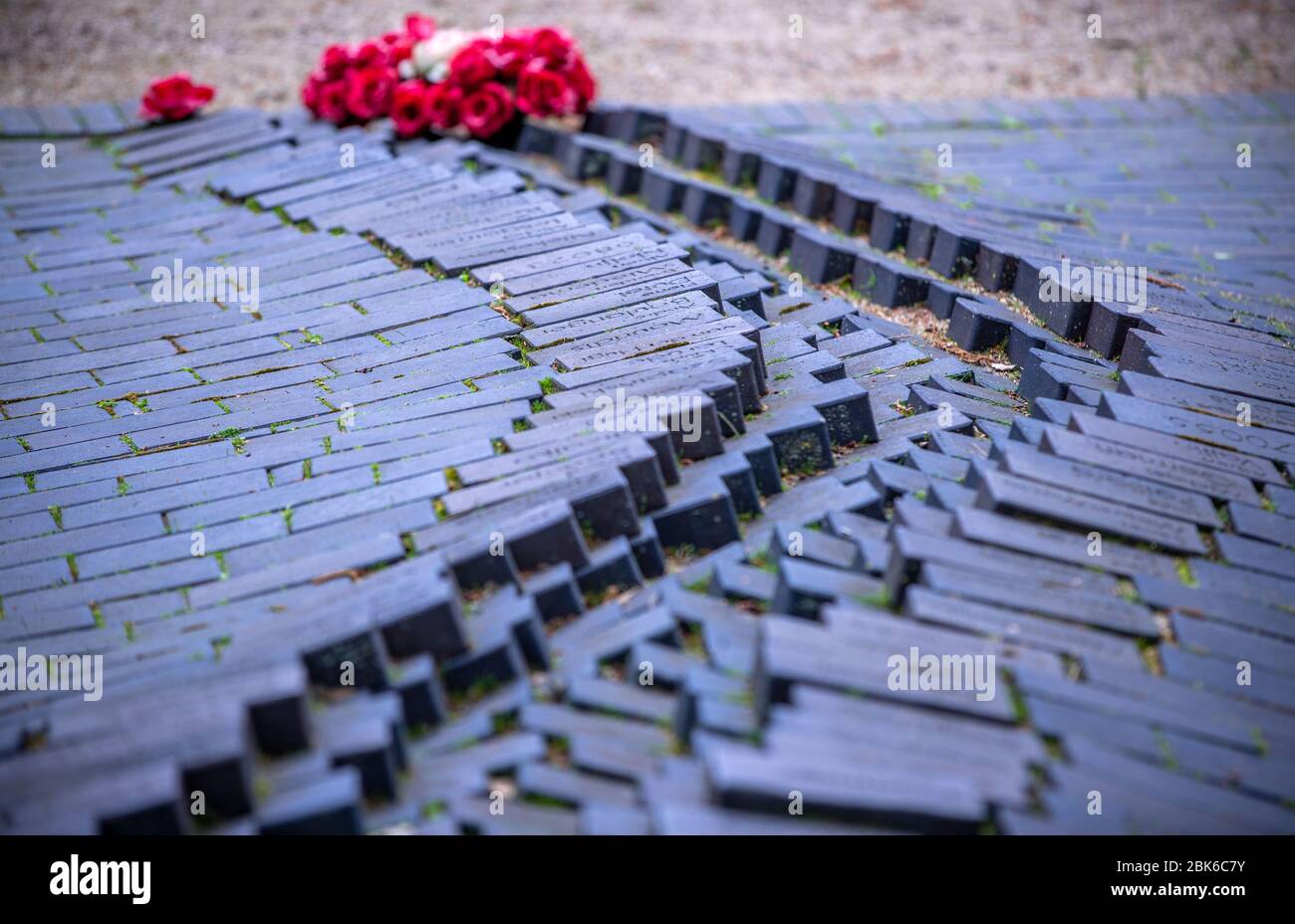 02. Mai 2020, Mecklenburg-Vorpommern, Wöbbelin: Eine Blumenarrangement befindet sich in der Gedenkstätte im ehemaligen Konzentrationslager Wöbbelin. Bei der Gedenkveranstaltung, die aufgrund der Corona-Schutzmassnahmen in der Teilnehmerzahl begrenzt ist, werden die mehr als 1,000 Opfer des KZ-Außenlagers gedenkt. Sie wurde am 2. Mai 1945 von US-Truppen befreit. Foto: Jens Büttner/dpa-Zentralbild/dpa Stockfoto