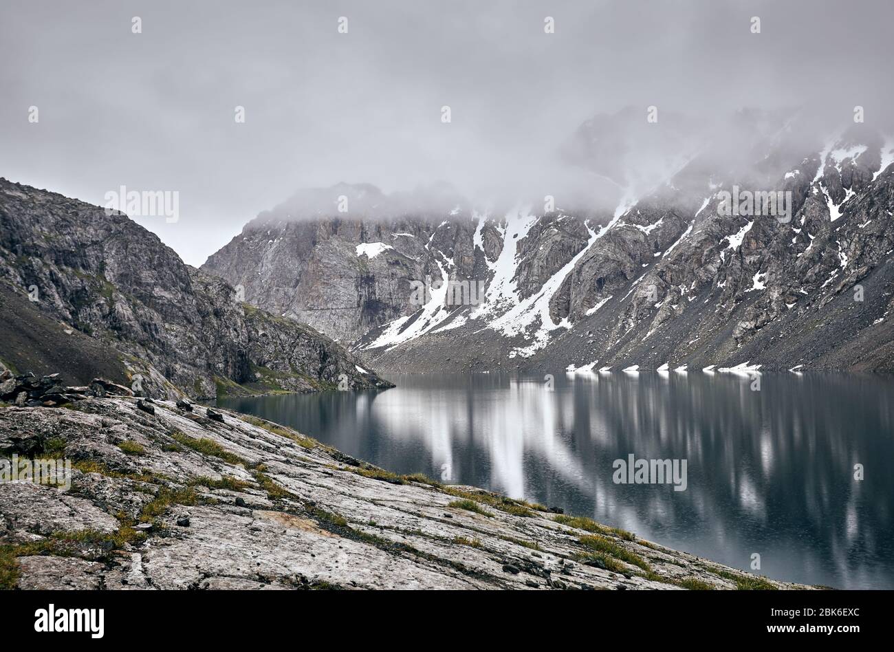 Schöne Landschaft von Ala-Kul See im Tien Shan Gebirge mit weißen Nebel Wolken in Karakol Nationalpark, Kirgisistan Stockfoto