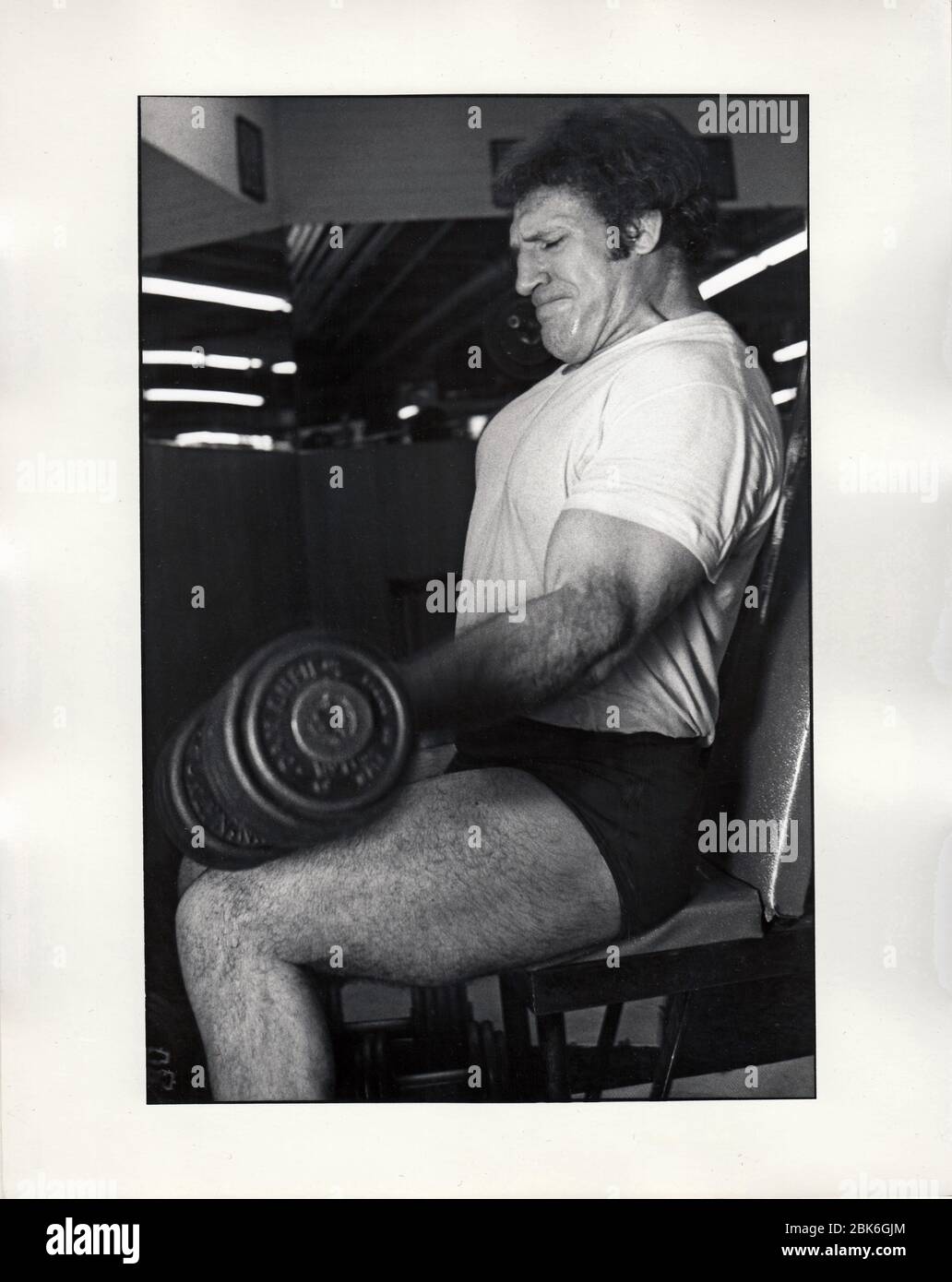 Der ehemalige Weltmeister Bruno Sammartino rollt in einem Fitnessstudio in Midtown Manhattan, New York City, sehr schwere Gewichte. Ca. 1975. Stockfoto