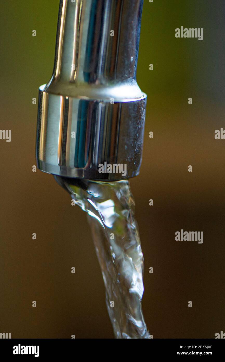 Wasser läuft aus dem Wasserhahn Stockfoto