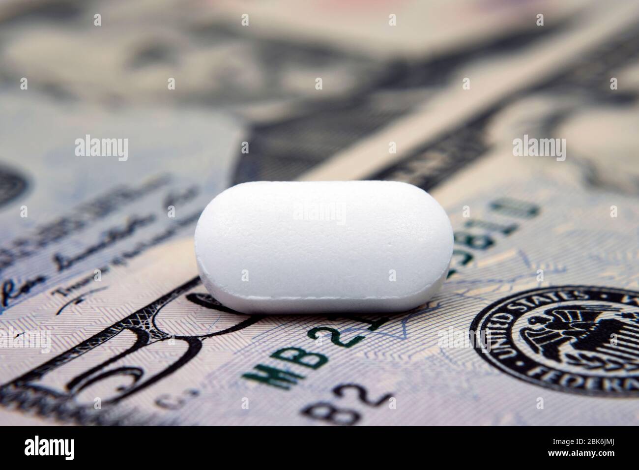 Pille auf 50 Dollar Banknote. Illustrativ für den Gewinn aus der pharmazeutischen Industrie, Kosten für Pillen und medizinische Versorgung. Konzeptfoto. Stockfoto