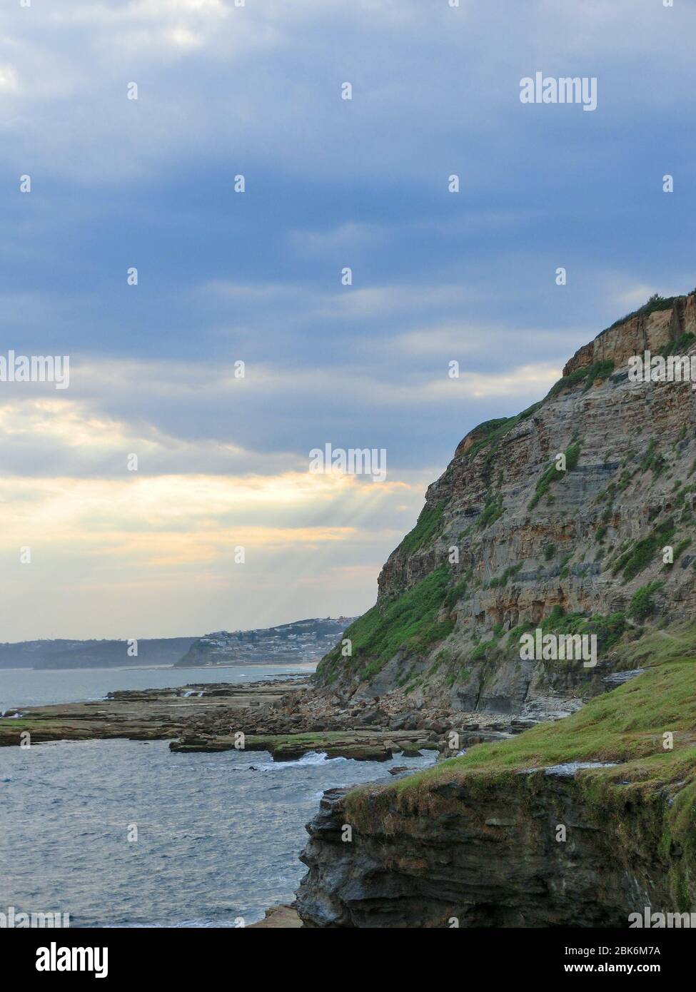 Sonnenstrahlen brechen durch die Wolken, Newcastle Cliffs, Australien Stockfoto