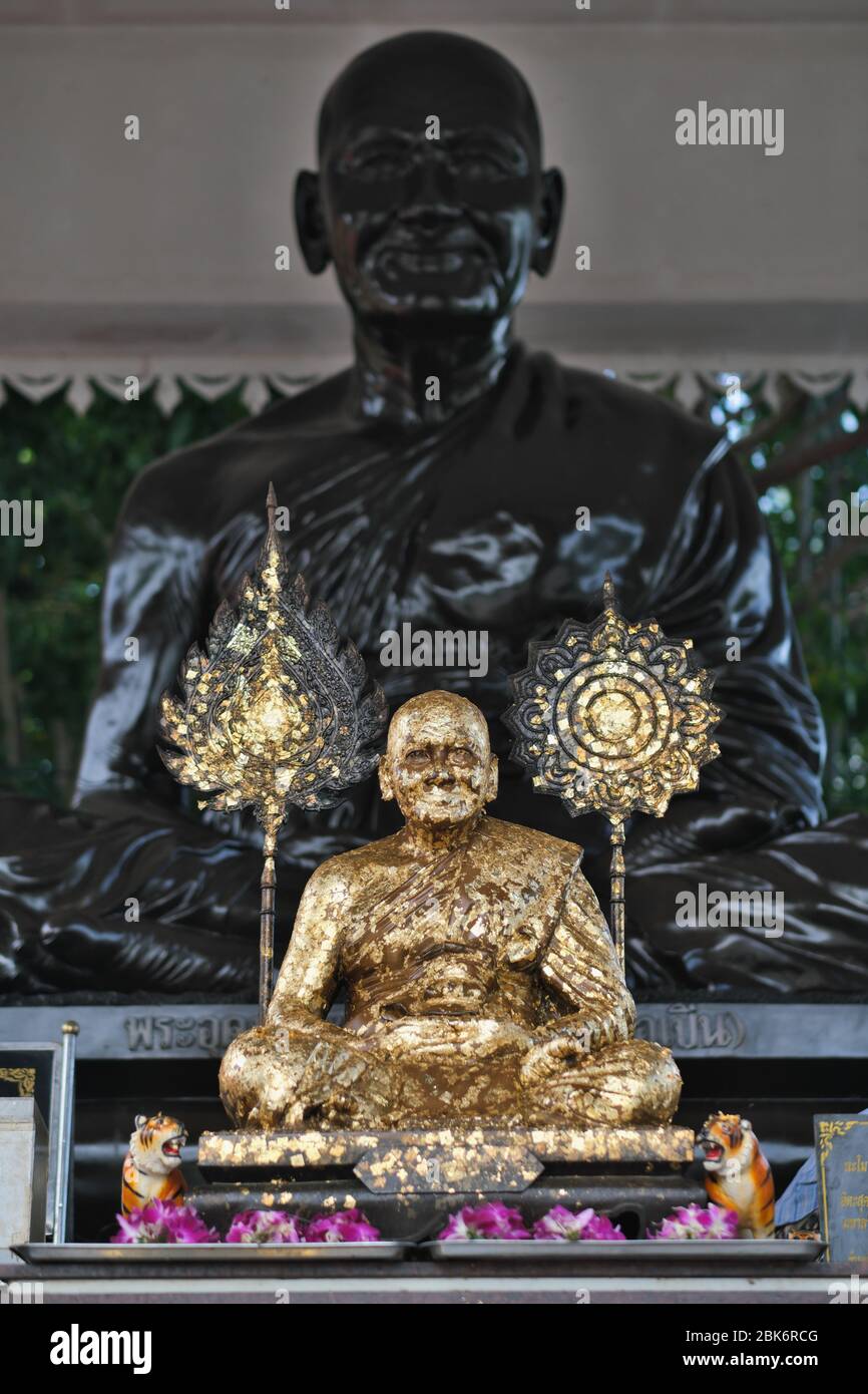 Eine vergoldete und eine schwarze Statue eines verehrten Mönchs; im Wat Bang Phra, berühmt für die magischen Tattoos, die dort verabreicht werden; in der Nähe von Nakhon Chaisi, Thailand Stockfoto
