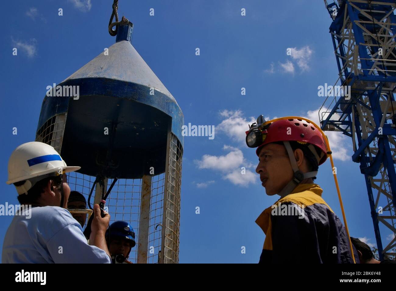 Speläologische Enthusiasten und ein Journalist steigen in einen vertikalen Bauaufzug für eine Exkursion zum Bribin Unterwasser-Projekt in Indonesien. Stockfoto