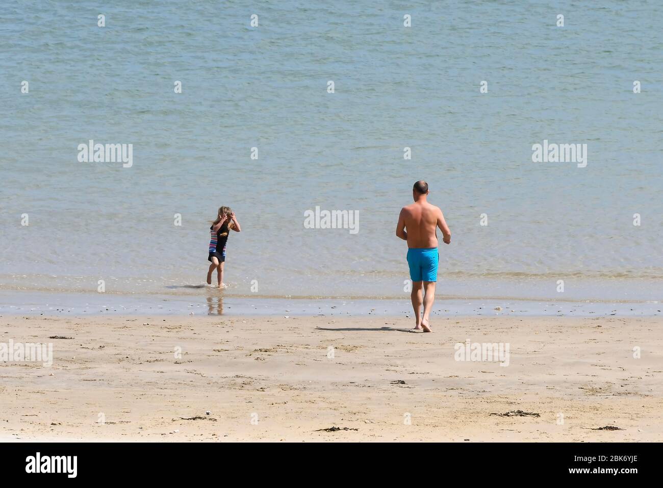 Lyme Regis, Dorset, Großbritannien. Mai 2020. Wetter in Großbritannien. Eine Familie in Richtung Meer schwimmen am Strand im Badeort Lyme Regis in Dorset an einem Tag der warmen Sonnenzauber während der Coronavirus Pandemie Sperrung gehen Bildnachweis: Graham Hunt / Alamy Live News Stockfoto