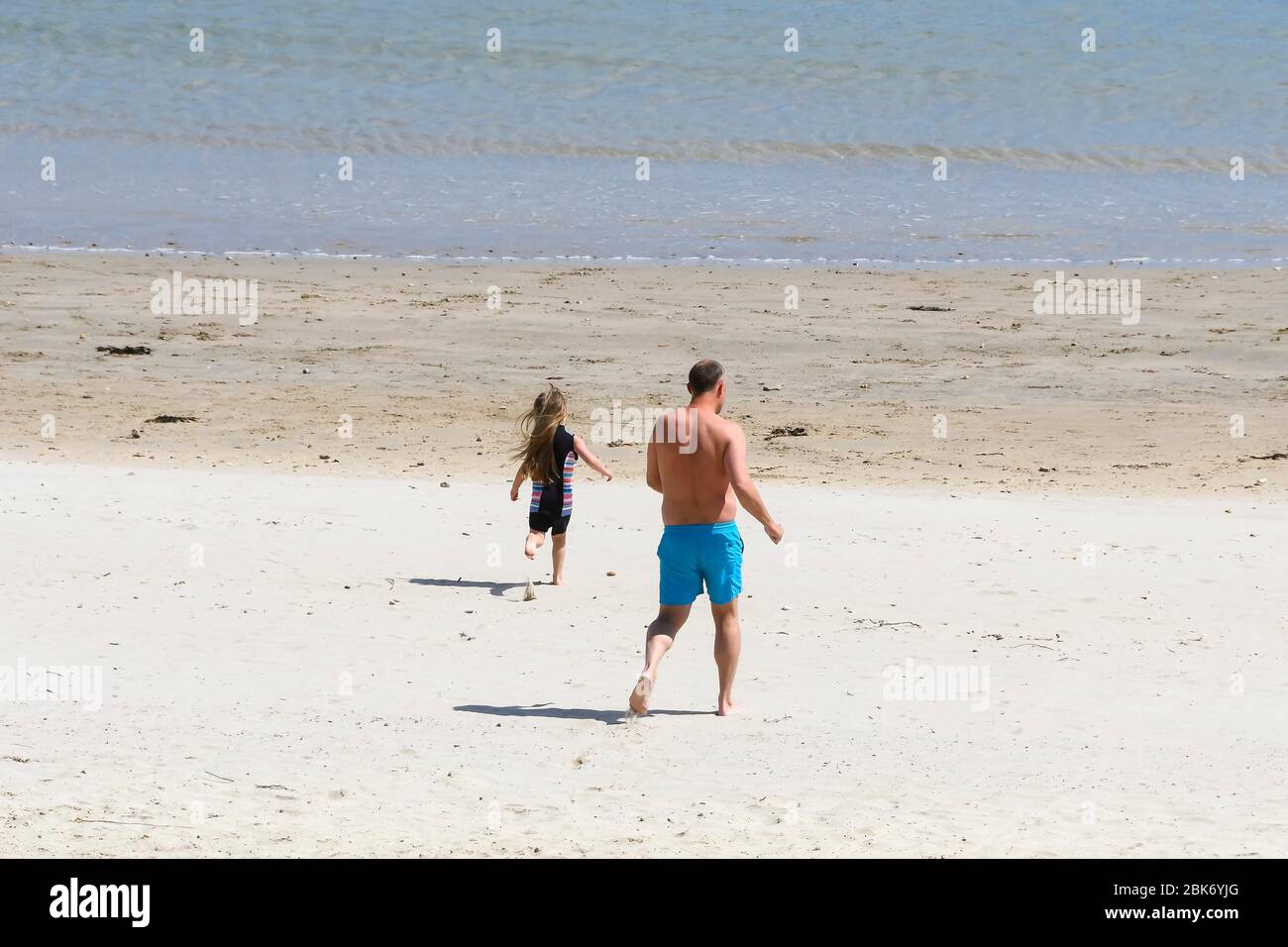 Lyme Regis, Dorset, Großbritannien. Mai 2020. Wetter in Großbritannien. Eine Familie in Richtung Meer schwimmen am Strand im Badeort Lyme Regis in Dorset an einem Tag der warmen Sonnenzauber während der Coronavirus Pandemie Sperrung gehen Bildnachweis: Graham Hunt / Alamy Live News Stockfoto