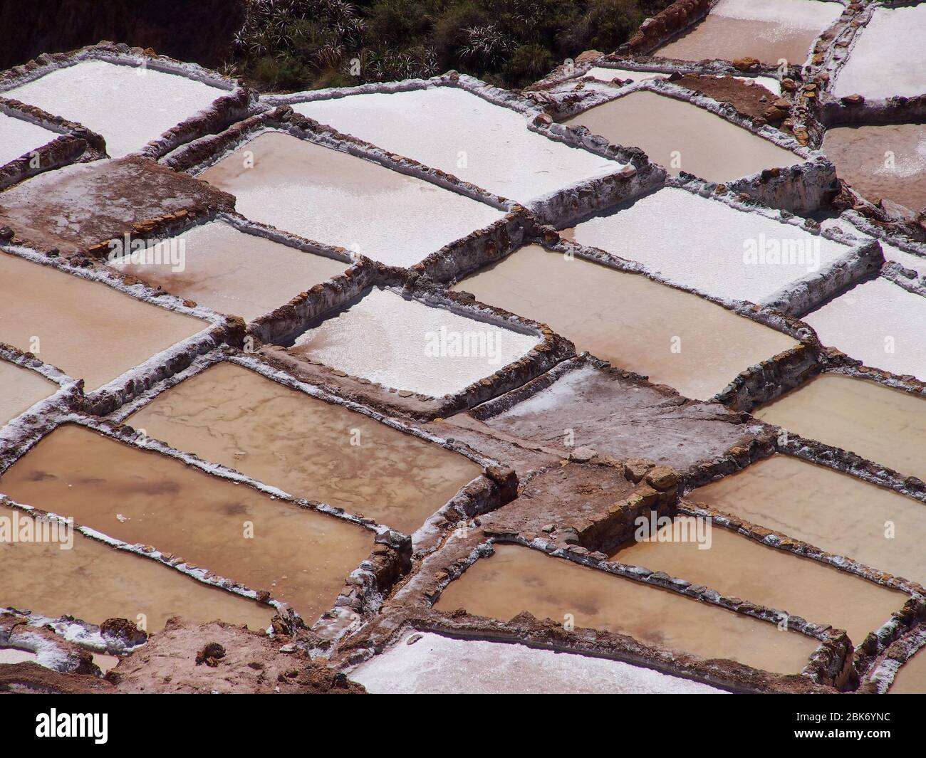 Sonnige und braune Salzminen in Maras, Peru Stockfoto